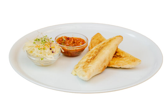 Calzone pastries dinner with salsa and cabbage salad on white plate