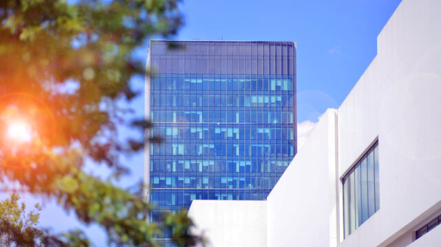 White concrete building wall against blue sky background, geometric exterior architecture.