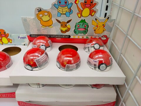 Malang, Indonesia - July 24, 2026: A retail display stand featuring Pok&eacute;mon "Palmsize Wonders" Pok&eacute; Ball blind capsules. Funism.  