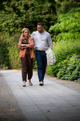 Fototapeta premium Couple walking on park path during a disagreement