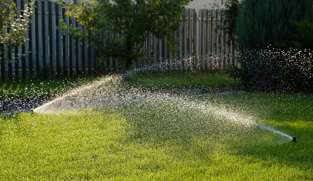 Automatic garden irrigation system watering lawn. Savings of water from sprinkler irrigation system with adjustable head. Automatic equipment for irrigation and maintenance of lawns, gardening.