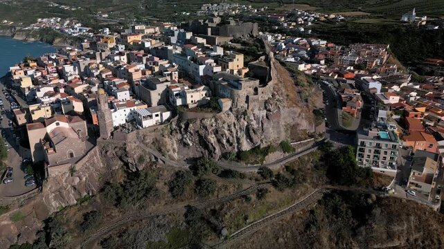 Panoramic aerial view of the Castelsardo, a medieval town in northern Sardinia (Sassari province) on the Gulf of Asinara. It features cascading, colorful houses and a historic fortress.