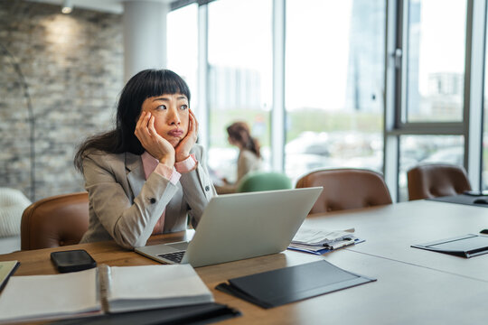 Woman experiencing boredom and frustration at office desk