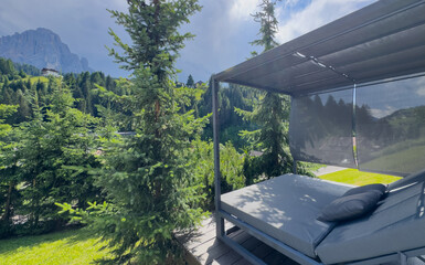 Obraz premium Modern patio furniture with sofa. Overlooks rich green mountain landscape. Sunny day bright airy atmosphere. Perfect outdoor living space