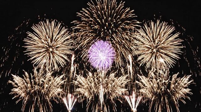 Vibrant multicolored fireworks display exploding in rapid succession on a dark black background