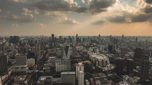 Bangkok city skyline at sunset with modern buildings, downtown urban panorama of Thailand capital with skyscrapers and evening sky, aerial drone view