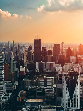 Bangkok city skyline at sunset with modern buildings, downtown urban panorama of Thailand capital with skyscrapers and evening sky, aerial drone view