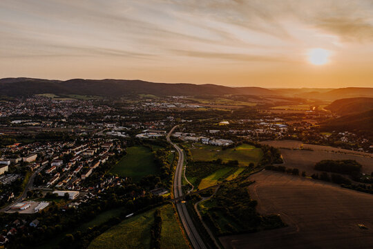 Spectacular aerial sunset landscape with a curving highway and rural town named Saalfeld