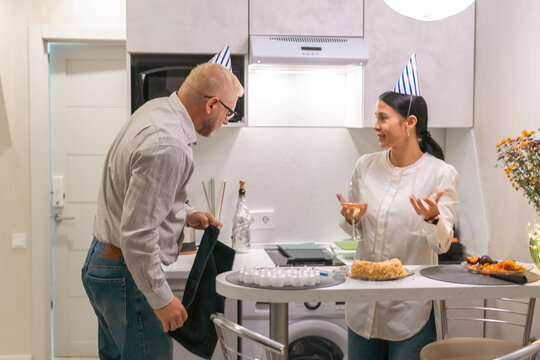Couple Birthday Kitchen Celebration: Happy mature couple celebrates birthday together in modern kitchen, enjoying intimate moment.