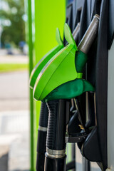 Green Fuel Pump Nozzles Stored in Dispenser Holders at a Modern Gas Station © Edijs