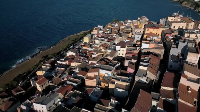 Panoramic aerial view of the Castelsardo, a medieval town in northern Sardinia (Sassari province) on the Gulf of Asinara. It features cascading, colorful houses and a historic fortress.