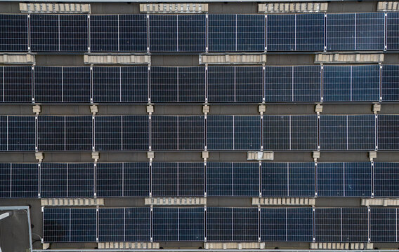 Close-up aerial view of solar panel array mounted in rows on flat commercial rooftop, renewable energy and photovoltaic installation detail concept.