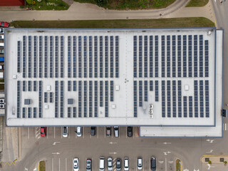 Fototapeta na wymiar Aerial top-down view of large commercial building rooftop covered with solar panels, renewable energy and sustainable business infrastructure concept.