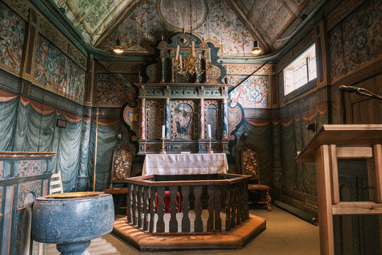 Interior shot of the sanctuary and carved altar retable with painted wall decorations inside Kaupanger Stave Church, the largest stave church in Sognefjord, Norway.
