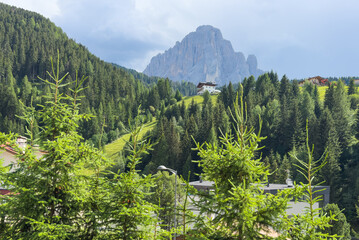 Obraz premium View of beautiful landscape in the Alps with fresh green meadows and mountain tops in the background on a sunny day with blue sky and clouds in summertime. Alpe di Cisles, Seceda Ridgeline, Dolomiti ,