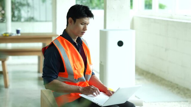 Construction worker in a safety vest holding a hard hat and looking stressed at a building site, representing workplace pressure, construction challenges and project management.