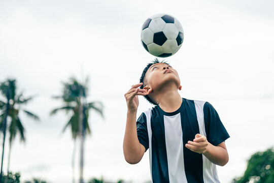 Kid boy leg kicking soccer ball on green grass field action. conceptual metaphor for youth sports training team competition fitness health wellness and active lifestyle