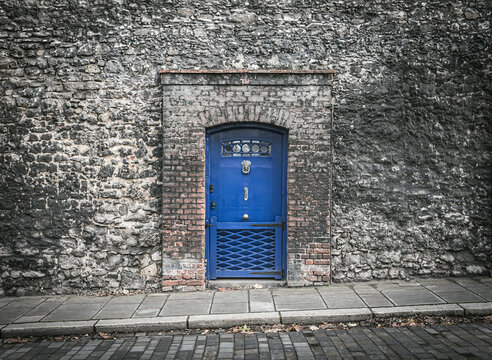 Mysterious blue door in an old stone wall of a prison