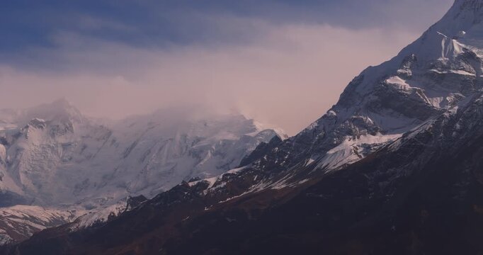 Annapurna Circuit, Manang, Nepal, drone panoramic shot across majestic snow-capped mountain peaks of the Annapurna range beneath a clear blue sky.
