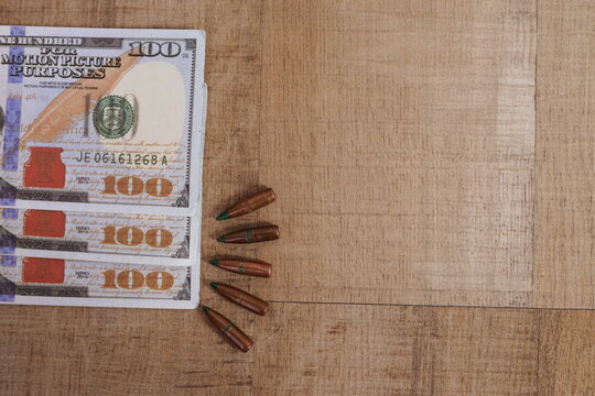Copy Space with Rifle Bullets Beside Stacked US Dollars