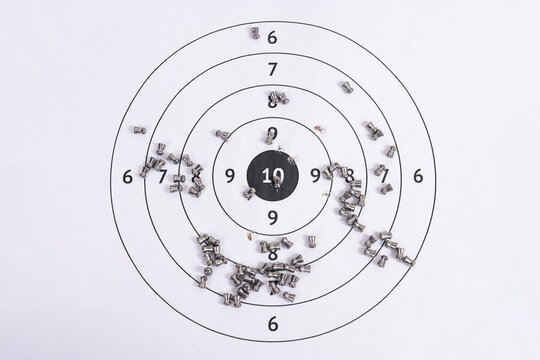 Flat Lay of Pierced Paper Target Sheet with Scattered Airgun Pellets