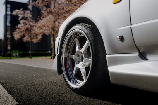 Extreme close up of a deep dish custom silver rim on a high performance sports car