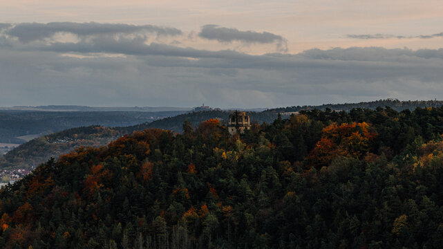 Autumn forest landscape with a historic bismarktower on a hill at dusk in Germany 