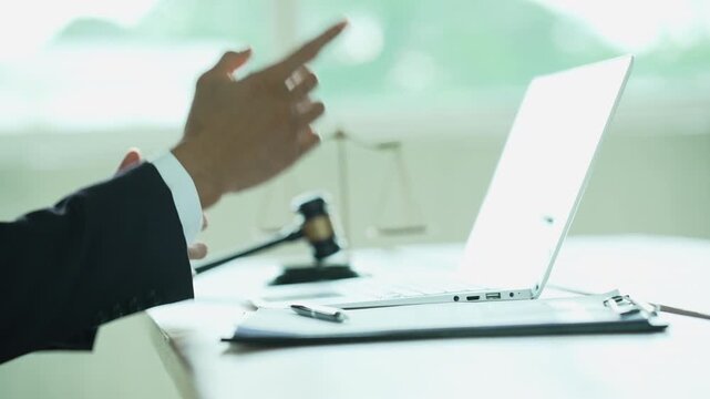 Lawyer working on a laptop with a gavel and scales of justice, representing legal technology, law practice, digital documents, justice, and professional legal services.