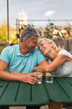 Happy mature couple embracing at a garden table