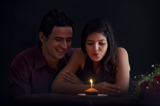 Woman blowing out a candle in a muffin