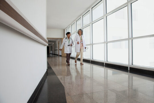 Two doctors in discussion walking down corridor