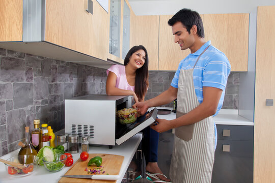 Happy couple preparing meal in kitchen