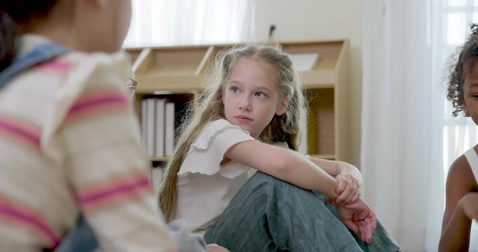 Young girl pupil sits in primary classroom circle, listening to peer and teacher during first day discussion, building attention, friendship, confidence, learning readiness and class respect