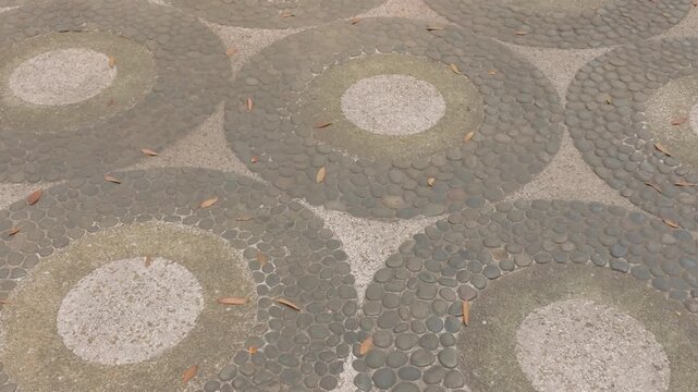 Decorative circular stone pattern on outdoor pavement surface.