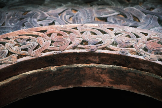 Detailed shot of a carved wooden archway with Scandinavian interlaced ornament motifs inside the 12th-century Borgund Stave Church in Vestland, Norway