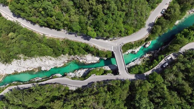 Aerial top down perspective captures turquoise Soca river crystal clear water. rocky canyon banks surrounded by dense wild green forest near Kobarid.