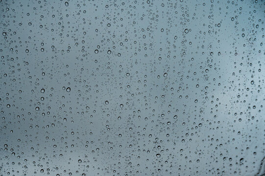 Raindrops on Water Resistant Tent Tarp Close Up. Macro photograph showing numerous fresh raindrops scattered across a waterproof camping tent fabric. The translucent water droplets