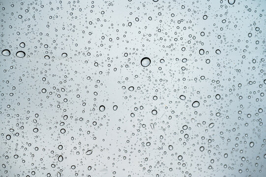 Raindrops on Water Resistant Tent Tarp Close Up. Macro photograph showing numerous fresh raindrops scattered across a waterproof camping tent fabric. The translucent water droplets