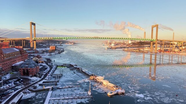 Aerial view of Alvsborg Bridge over the frozen Gota alv river with industrial buildings in the Klippan area of Goteborg, Vastra Gotalands lan, Sweden.