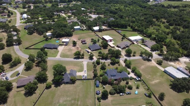 Single family acreage lots surrounded by tree canopies line County Road 602 in Dallas Fort Worth. Overhead vantage highlights residential layouts, concrete driveways, outbuildings. Burleson, TX