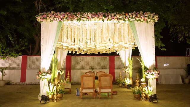 Traditional Indian wedding mandap stage decorated with flowers for night ceremony in India