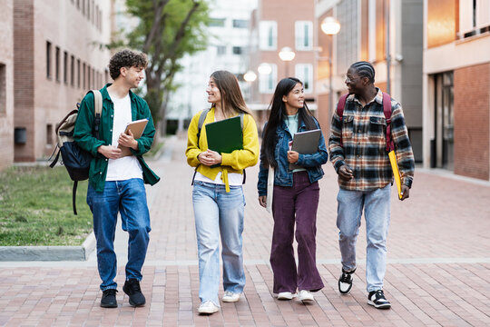 Smilingt sudents walking on university campus after class, bonding education friends in global diversity scholarship 