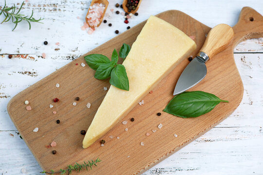 parmesan cheese and basil on wooden board