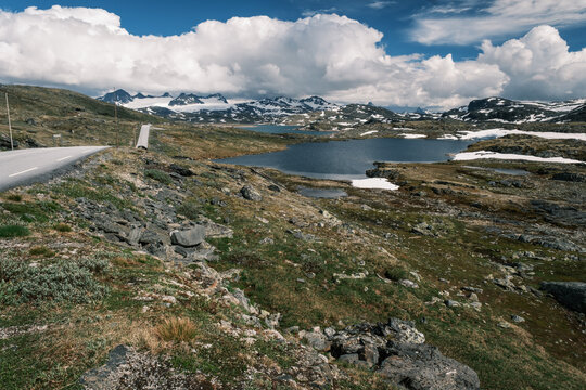 Panoramic vista of the desolate arctic tundra landscape dotted with glacial tarns along the high-altitude Sognefjellet scenic road in Norway