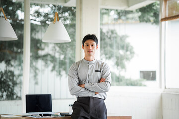 Fototapeta premium Smiling Asian businessman using a digital tablet and stylus in a modern office, representing digital work, technology, communication, productivity, and professional business.