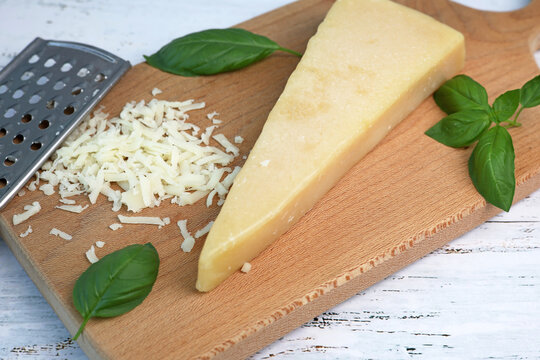 parmesan cheese and basil on wooden board