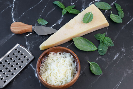 parmesan cheese and basil on black marble