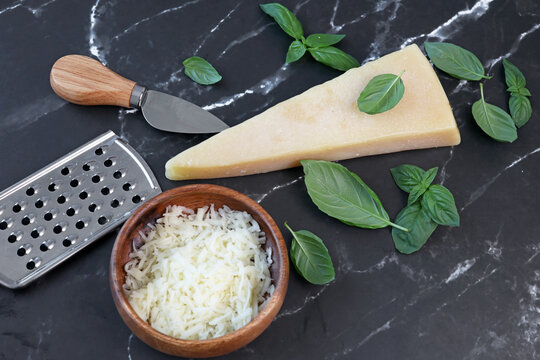 parmesan cheese and basil on black marble