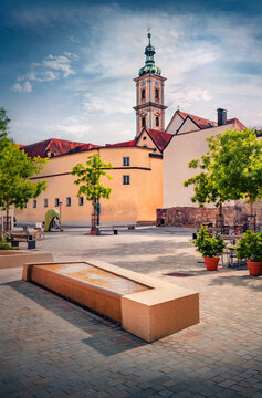 Attractive evening view of Bell Tower of Carmelite Monastery Regensburg. Captivating summer cityscape of Regensburg with empty square and fountain in the shape of sit, Germany, Europe. 