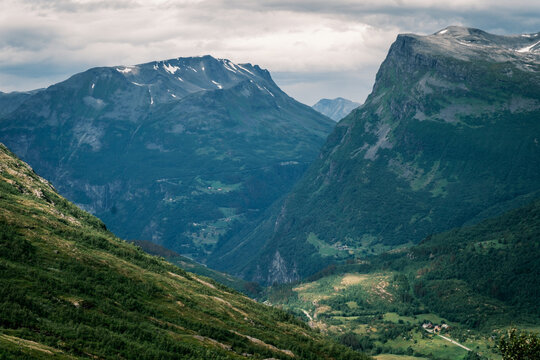 Elevated vista from the Fv55 Sognefjellsvegen pass overlooking dramatic U-shaped glacial valley walls and distant mountain peaks in Vestland, Norway.
